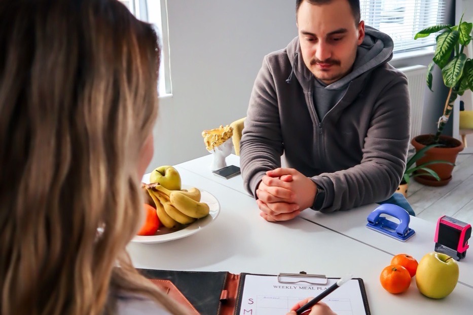 A dietitian consulting with a patient across a clinic desk