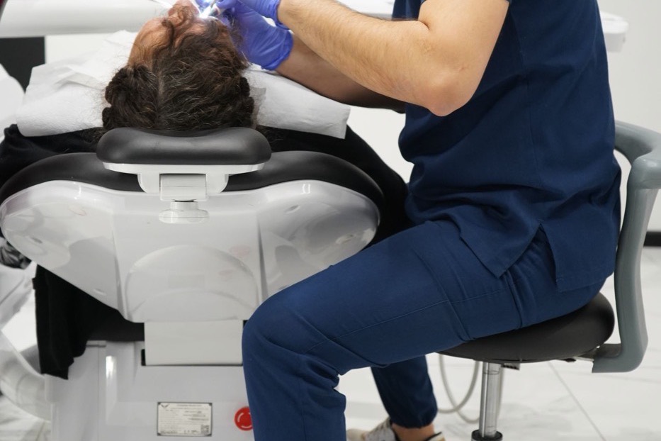 Dentist treating a patient reclined in the chair during a dental appointment